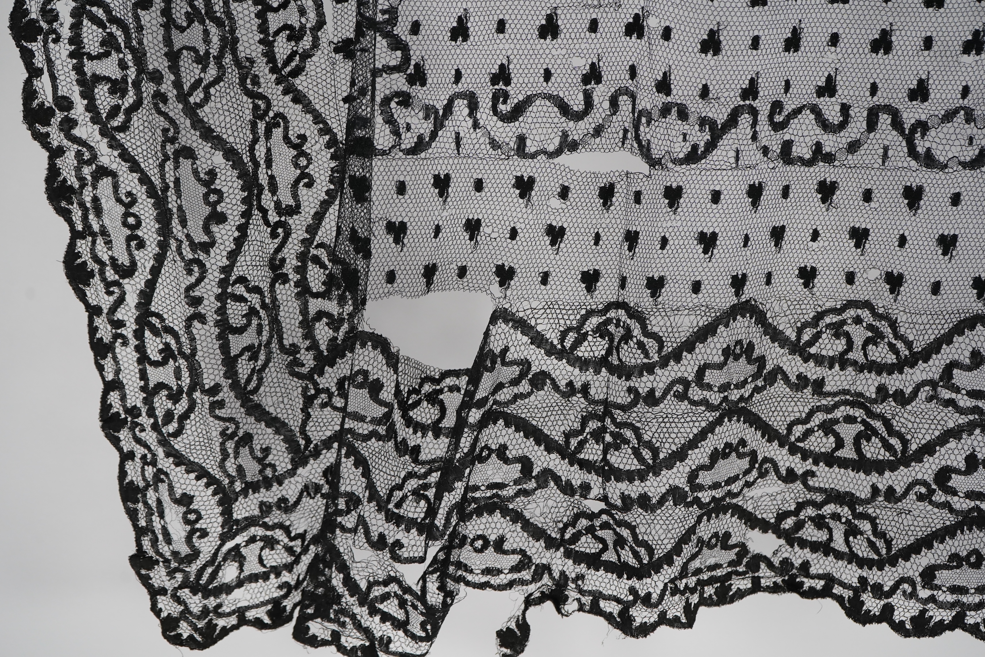 A collection of mixed machine lace: a black lace stole, two black veils, a sample of Japanese brocade, a length of metallic ribboning and various items of cream lace, ribboning 230cm long. Condition - variable poor to fa